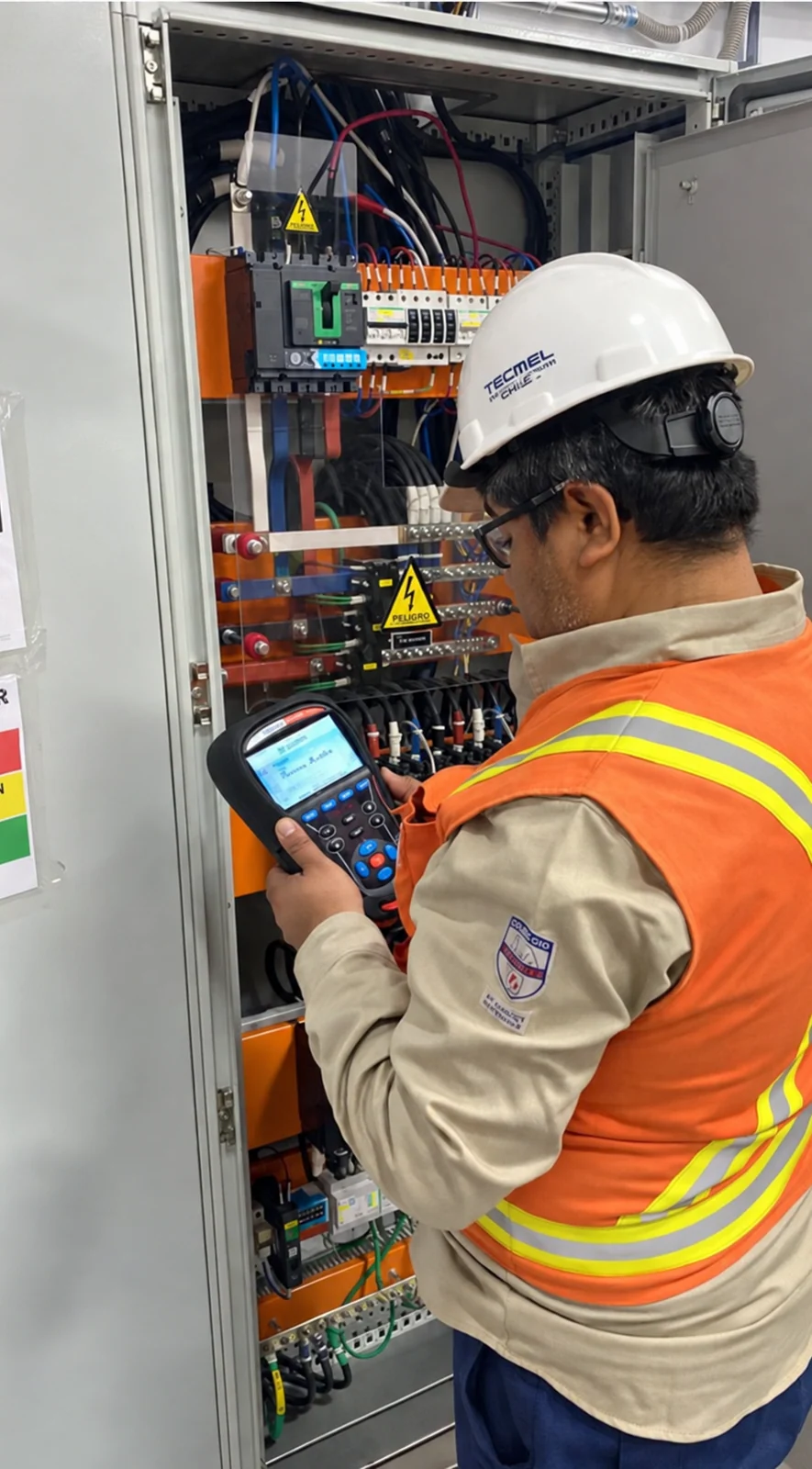 Profesional realizando mediciones en un tablero eléctrico industrial